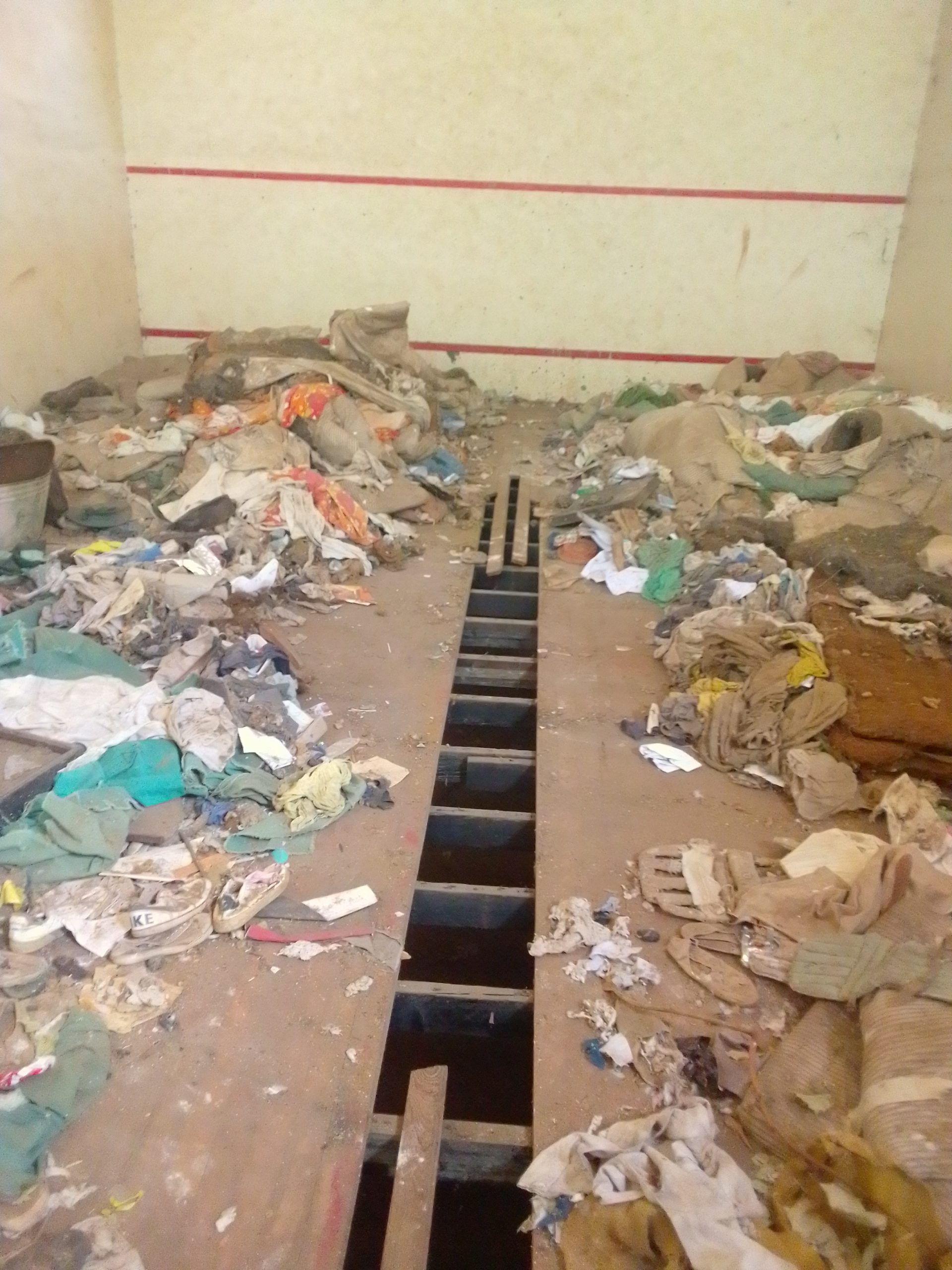 Broken squash court in Zimbabwe with rubbish all over it