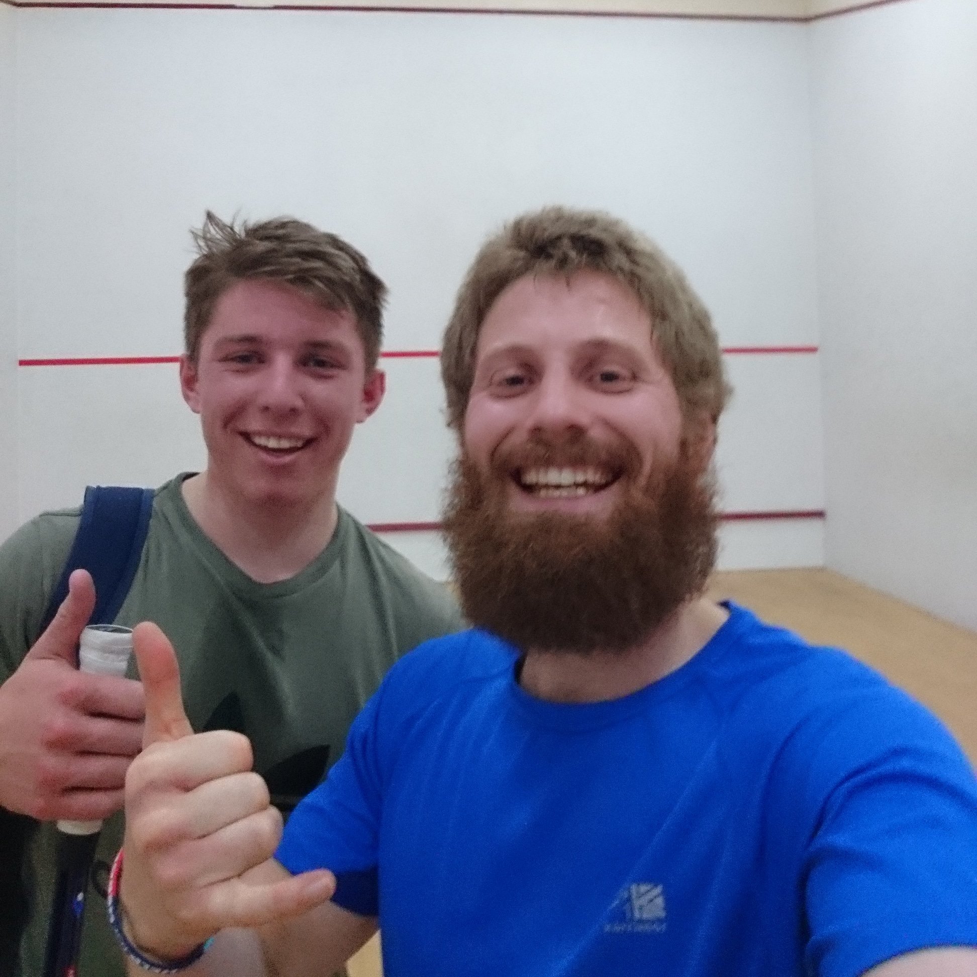 Nathan Wells smiles with squash athlete who he coaches with strength and conditioning