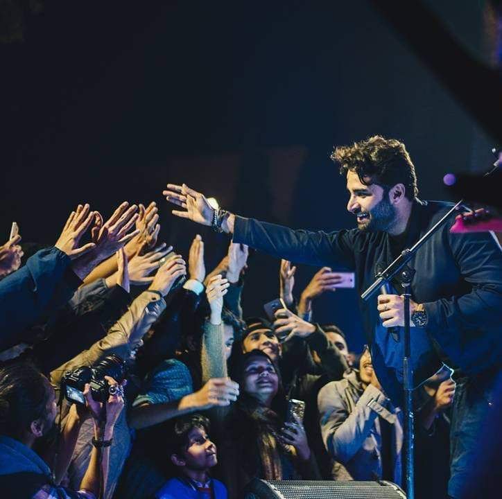 Bilal Ali shakes hands with fans off stage