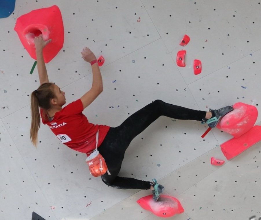 anja mikulic bouldering on overhanging wall in climbing gym