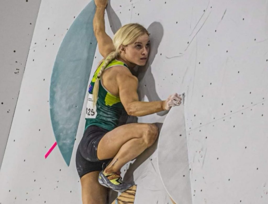 Woman climber climbs indoor gym