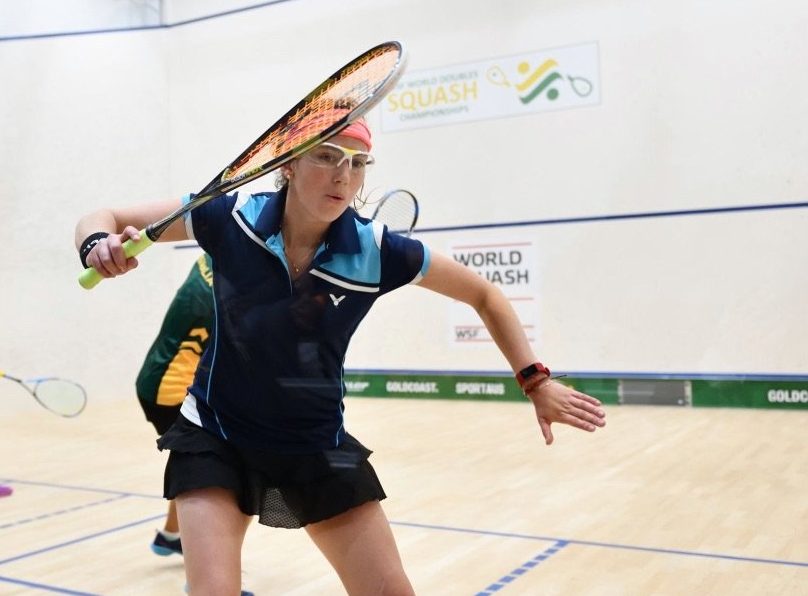 female squash player hitting a shot during match
