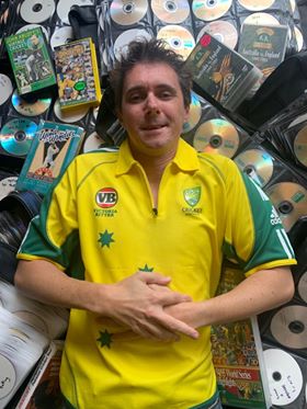 Rob Moody wearing the Australian cricket Jersey lying in front of his recordings of games