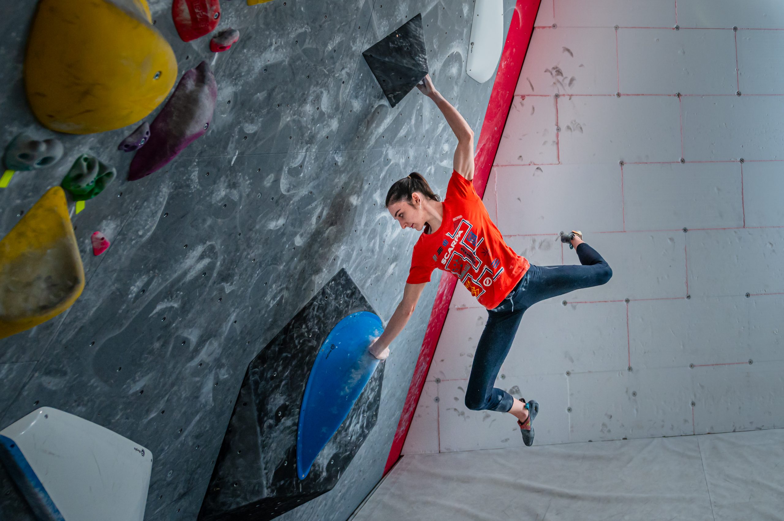 Mia Krampl hoists herself up the wall she is climbing